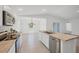 Modern kitchen with stainless steel appliances, an island with a sink, and an open view to the dining area at 2032 Jagust Rd, North Port, FL 34288
