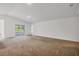 Spacious living room with neutral carpet, plenty of natural light from sliding doors, and an open floor plan at 2032 Jagust Rd, North Port, FL 34288