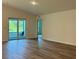 Neutral living room featuring wood-look floors and sliding glass doors leading to outdoor seating at 2032 Jagust Rd, North Port, FL 34288
