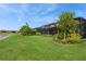 Expansive backyard with lush green lawn, meticulous landscaping, and a screened-in patio at 20660 Ovid Ln, Venice, FL 34293