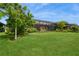 The sprawling backyard features a lush lawn, manicured landscaping, and a screened-in porch at 20660 Ovid Ln, Venice, FL 34293