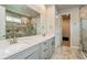 Bathroom with marble floors, double sinks and a glass enclosed shower with tiled walls at 20660 Ovid Ln, Venice, FL 34293