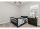 Simple bedroom with neutral carpet, one window and a black bed frame with navy and gray bedding at 20660 Ovid Ln, Venice, FL 34293