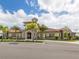 Beautiful community clubhouse with stone accents, palm trees, and well-manicured landscaping at 20660 Ovid Ln, Venice, FL 34293