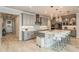 Bright kitchen featuring gray cabinets, stainless steel appliances, and a spacious quartz-topped island with bar seating at 20660 Ovid Ln, Venice, FL 34293