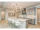 Well-lit kitchen featuring a quartz island with bar seating, modern pendant lights, and gray cabinets at 20660 Ovid Ln, Venice, FL 34293