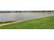 Picturesque view of the serene lake from the backyard showing calm water and lakeside landscaping at 20660 Ovid Ln, Venice, FL 34293