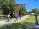 Gathering rides bikes along the Legacy Trail, surrounded by lush greenery on a sunny day at 20660 Ovid Ln, Venice, FL 34293