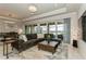 Cozy living room featuring a plush brown sectional sofa, modern lighting, and access to an outdoor patio with pool views at 20660 Ovid Ln, Venice, FL 34293