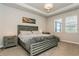 Cozy main bedroom with tray ceilings, carpeted floors and a large platform bed with a headboard at 20660 Ovid Ln, Venice, FL 34293
