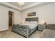 Carpeted main bedroom featuring tray ceilings, a platform bed and an ensuite bathroom at 20660 Ovid Ln, Venice, FL 34293