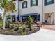 Charming outdoor seating area with tables and chairs under blue striped awnings, surrounded by greenery and elegant architecture at 20660 Ovid Ln, Venice, FL 34293