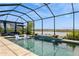 Screened-in pool area overlooking a lake, complete with outdoor seating and space for lounging at 20660 Ovid Ln, Venice, FL 34293