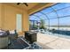 Screened in patio featuring a luxury pool with sun loungers, outdoor seating, and a lake view at 20660 Ovid Ln, Venice, FL 34293