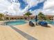 Inviting community pool area with comfortable seating, lush landscaping, and a relaxing hot tub at 20660 Ovid Ln, Venice, FL 34293