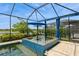 A beautiful spa with blue tile design located beside a screened in pool and a lake view at 20660 Ovid Ln, Venice, FL 34293