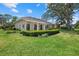 Exterior view of home and screened in patio surrounded by mature trees, lawn, and manicured shrubbery at 2092 Timucua Trl, Nokomis, FL 34275
