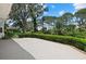 Backyard with well-manicured bushes, mature trees, green lawn and a concrete patio area at 2092 Timucua Trl, Nokomis, FL 34275
