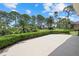 Landscaped backyard features well-manicured bushes, various trees, and a concrete patio area at 2092 Timucua Trl, Nokomis, FL 34275