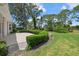 Backyard with mature trees, green lawn, concrete patio, and manicured bushes and plants at 2092 Timucua Trl, Nokomis, FL 34275
