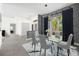 Elegant dining room with modern chandelier, wallpaper accent wall and glass table at 2092 Timucua Trl, Nokomis, FL 34275