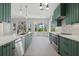 Open kitchen with island, custom green cabinets, and stainless steel appliances at 2092 Timucua Trl, Nokomis, FL 34275