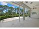 Enclosed patio featuring ceiling fans and views of a lush green lawn, trimmed bushes, and mature trees at 2092 Timucua Trl, Nokomis, FL 34275