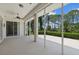 Enclosed patio with view to beautifully landscaped backyard featuring trimmed bushes and mature trees at 2092 Timucua Trl, Nokomis, FL 34275