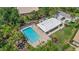 Aerial view of community pool surrounded by lush greenery and lounging area at 2092 Timucua Trl, Nokomis, FL 34275