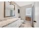 Well-lit bathroom with a large mirror, white vanity, and a shower with decorative curtain at 2311 Sandlewood Dr, Venice, FL 34293