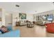 Bright living room features comfortable seating, modern decor, and large windows with a serene outdoor view at 2311 Sandlewood Dr, Venice, FL 34293