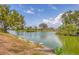 Scenic waterfront view with lush greenery, tranquil waters, and blue sky, offering a peaceful setting at 2311 Sandlewood Dr, Venice, FL 34293