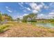Backyard view of a waterfront property showing a serene canal surrounded by lush greenery at 2311 Sandlewood Dr, Venice, FL 34293