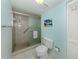 Bathroom with tiled shower, glass door, and palm tree painting at 232 Cerromar Way # 38, Venice, FL 34293