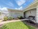 Close-up of an inviting home entrance with bench and manicured landscaping, perfect for relaxing outdoors at 232 Cerromar Way # 38, Venice, FL 34293