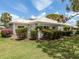 Charming home with lush landscaping, including vibrant flowers and well-maintained bushes, creating a serene outdoor space at 232 Cerromar Way # 38, Venice, FL 34293