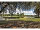 Scenic golf course view featuring a tranquil lake, sandy bunker, and lush green landscape with palm trees and clear blue skies at 232 Cerromar Way # 38, Venice, FL 34293