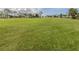 Wide shot of a meticulously maintained green golf course fairway, showcasing the lush landscape under a bright sky with scattered clouds at 232 Cerromar Way # 38, Venice, FL 34293