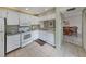 White kitchen with stainless steel sink, white appliances, and granite countertops at 232 Cerromar Way # 38, Venice, FL 34293
