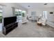 Well-lit living room with comfortable furnishings, a sliding glass door, and an entertainment center, perfect for relaxing at 232 Cerromar Way # 38, Venice, FL 34293