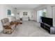 Bright living room with neutral carpet, a large sliding glass door, and comfortable seating, perfect for relaxation at 232 Cerromar Way # 38, Venice, FL 34293