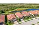 Aerial view displaying homes with red tile roofs, green lawns, and views of natural water features at 23493 Copperleaf Dr, Venice, FL 34293