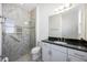 Bathroom with a walk-in shower with beautiful tile work, a white vanity, and granite countertops at 23493 Copperleaf Dr, Venice, FL 34293