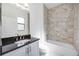 The bathroom showcases a vanity with a dark countertop, complemented by tiled walls and a shower-tub combination at 23493 Copperleaf Dr, Venice, FL 34293