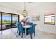 Bright dining area with seating for six, modern chandelier, and sliding doors offering a view to the outside at 23493 Copperleaf Dr, Venice, FL 34293