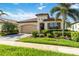 Charming single-story home with a red tile roof, lush landscaping, and a two-car garage at 23493 Copperleaf Dr, Venice, FL 34293