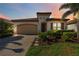 Charming single-story home with a terracotta roof, a well-manicured lawn, and mature landscaping at 23493 Copperleaf Dr, Venice, FL 34293