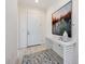 A bright foyer features tile floors, a console table with decor, and a view of the front door at 23493 Copperleaf Dr, Venice, FL 34293