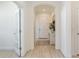 A bright hallway features tile floors, an arched doorway, and a view of the front door at 23493 Copperleaf Dr, Venice, FL 34293