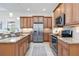 Spacious kitchen featuring stainless steel appliances, granite countertops, and wood cabinets with under-cabinet lighting at 23493 Copperleaf Dr, Venice, FL 34293